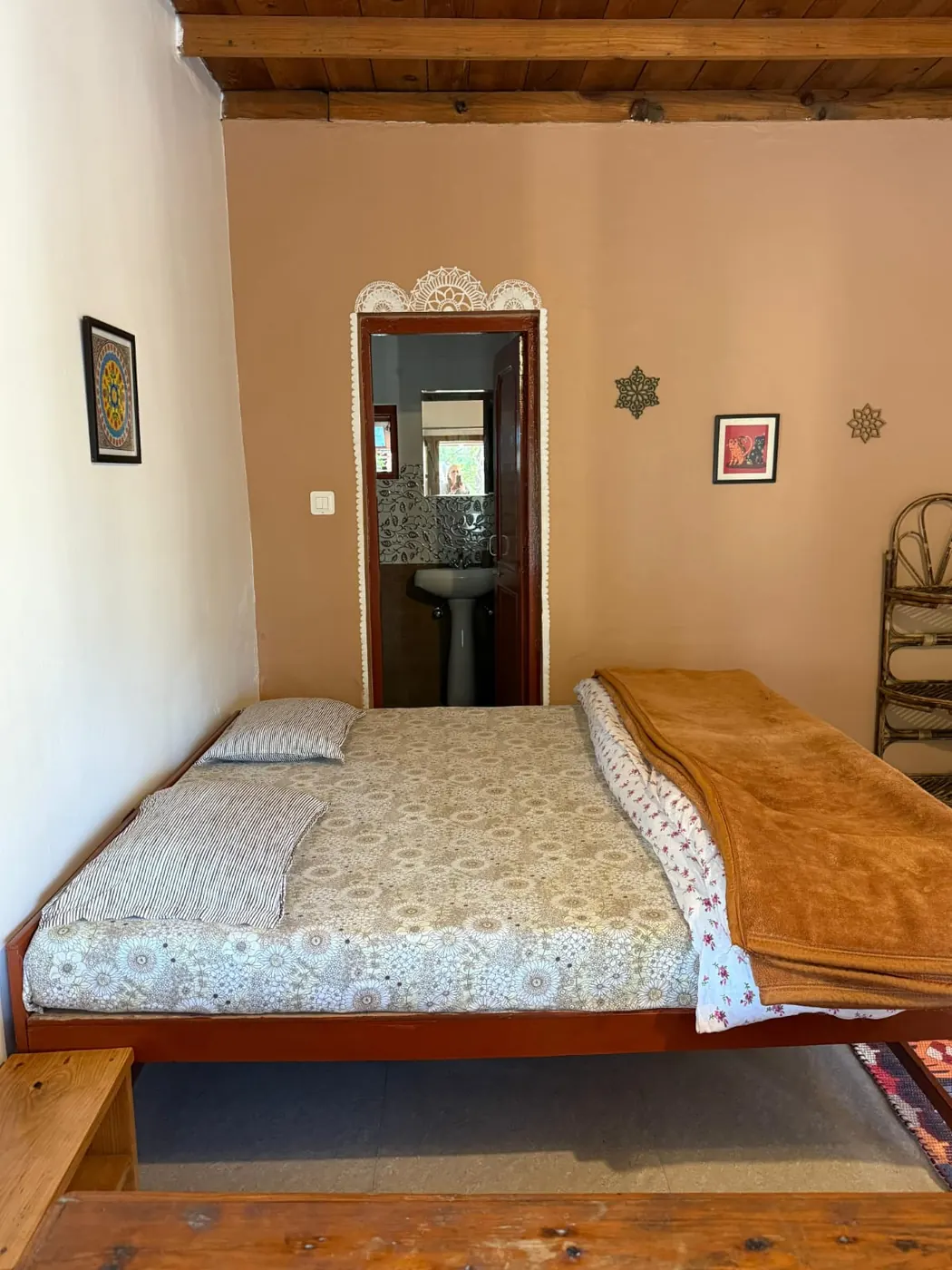 Twin room at Trimurti with warm bedding and a private washroom doorway.