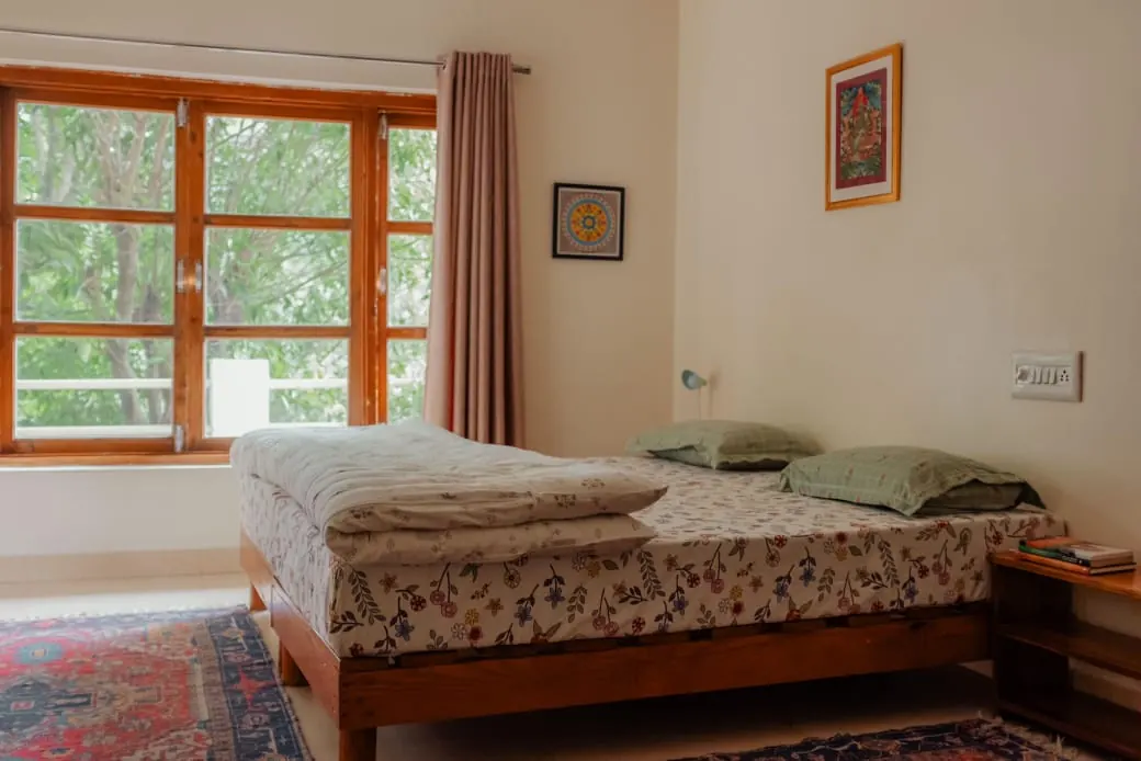 Twin guest room at Trimurti beside a large window.
